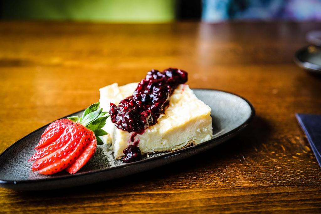 普尔伯勒环岛酒店的一块蛋糕和草莓放在桌子上的盘子里