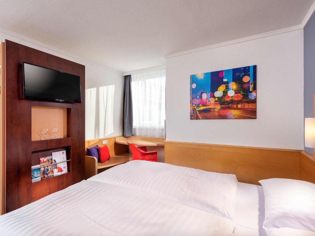 梅尔松根宜必思卡塞麦苏根酒店的配有一张床和一台平面电视的酒店客房