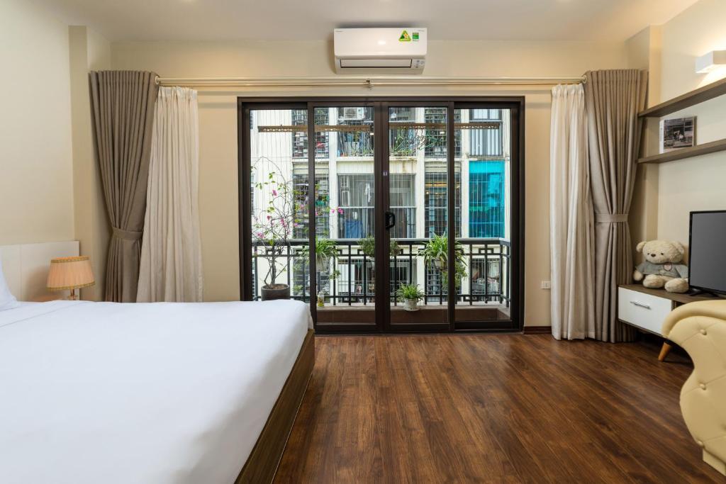河内YR Hotel & Apartments的一间卧室设有一张床和一个滑动玻璃门