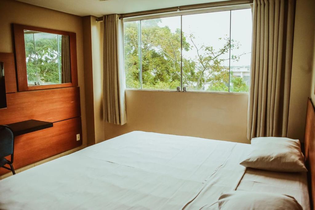 圣塔伦Barrudada Tropical Hotel的一间卧室设有一张床和一个大窗户