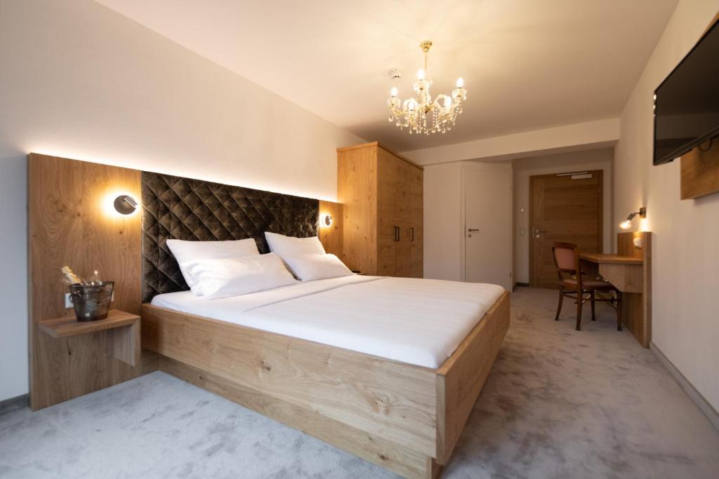 布鲁克安德格罗斯哥Thurners Boutique Hotel的一间卧室配有一张大床和一个吊灯。