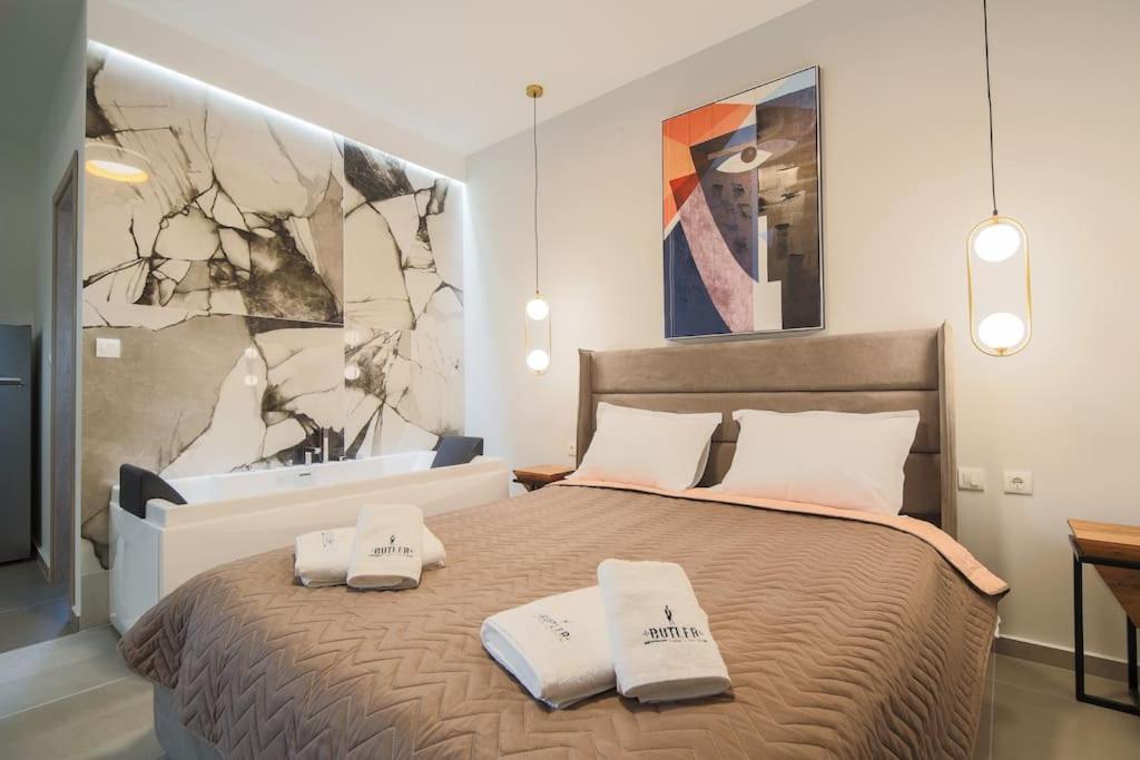 沃洛斯*Oasis* Best View Jacuzzi New Central Apartment的一间卧室配有一张床,上面有两条毛巾