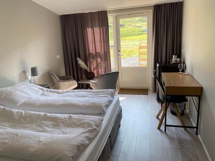 Norðurfjörður厄尔达丁德尔小屋酒店的酒店客房配有一张床、一张书桌和一张书桌。