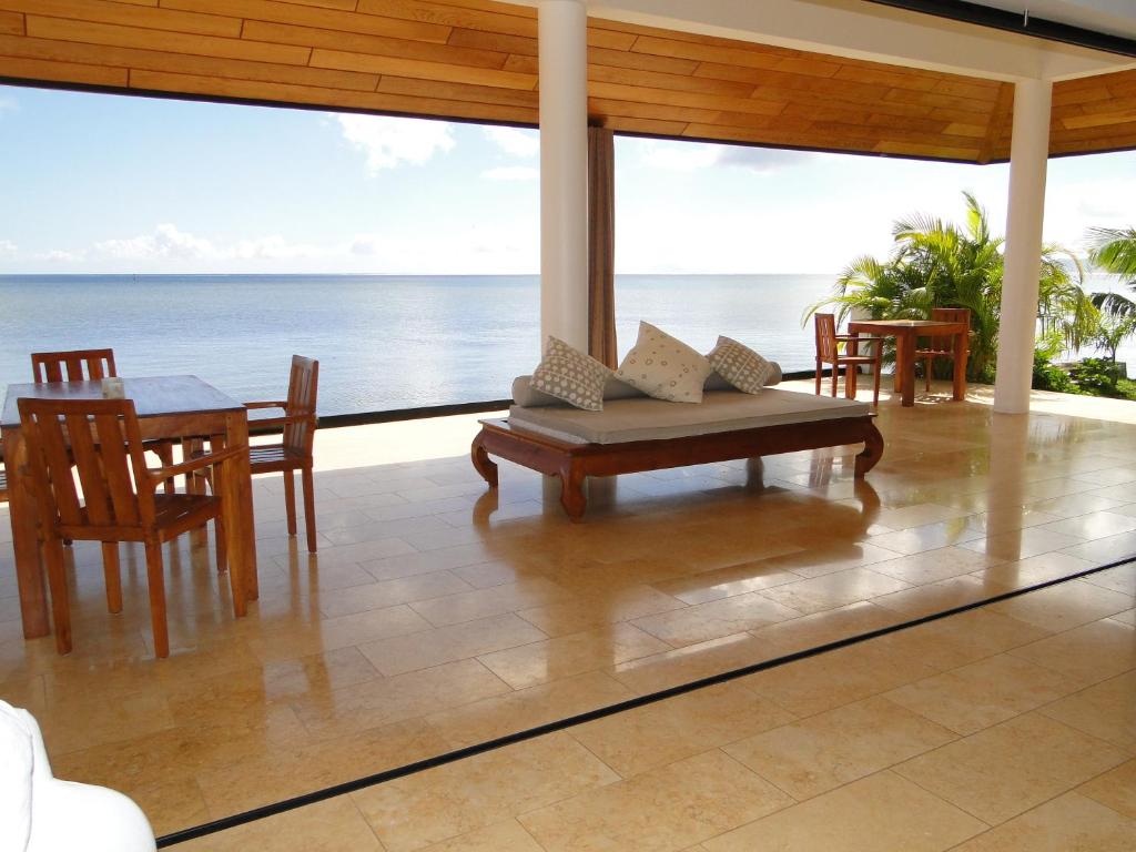 TevaitoaOcean Breeze Villa的一个带桌椅的门廊和大海