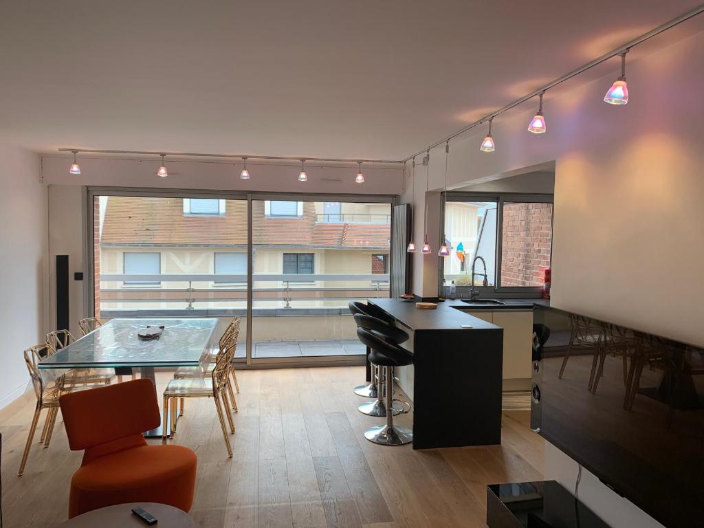 勒图凯-巴黎普拉日Appartement design en plein centre du Touquet的厨房以及带桌椅的用餐室。
