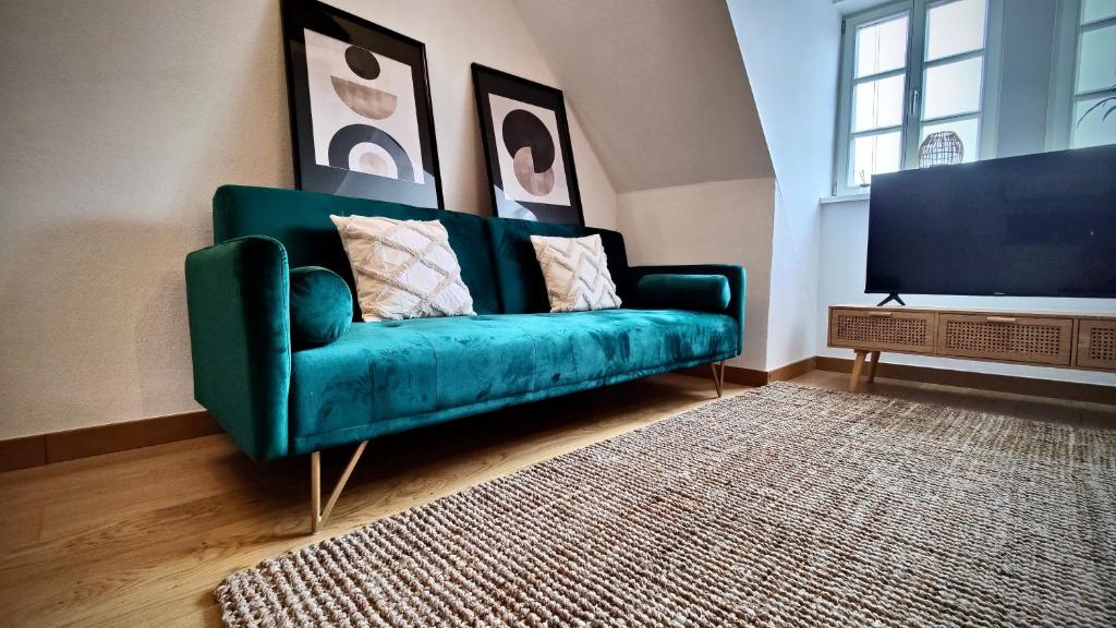 科堡One Apartment's⎢Neu+Zentral⎢Alberstplatz⎢Altbau的客厅里设有一张绿色沙发,配有电视