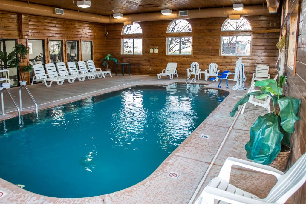Loves ParkQuality Inn & Suites Loves Park near Rockford的一个带椅子和桌子的大型游泳池