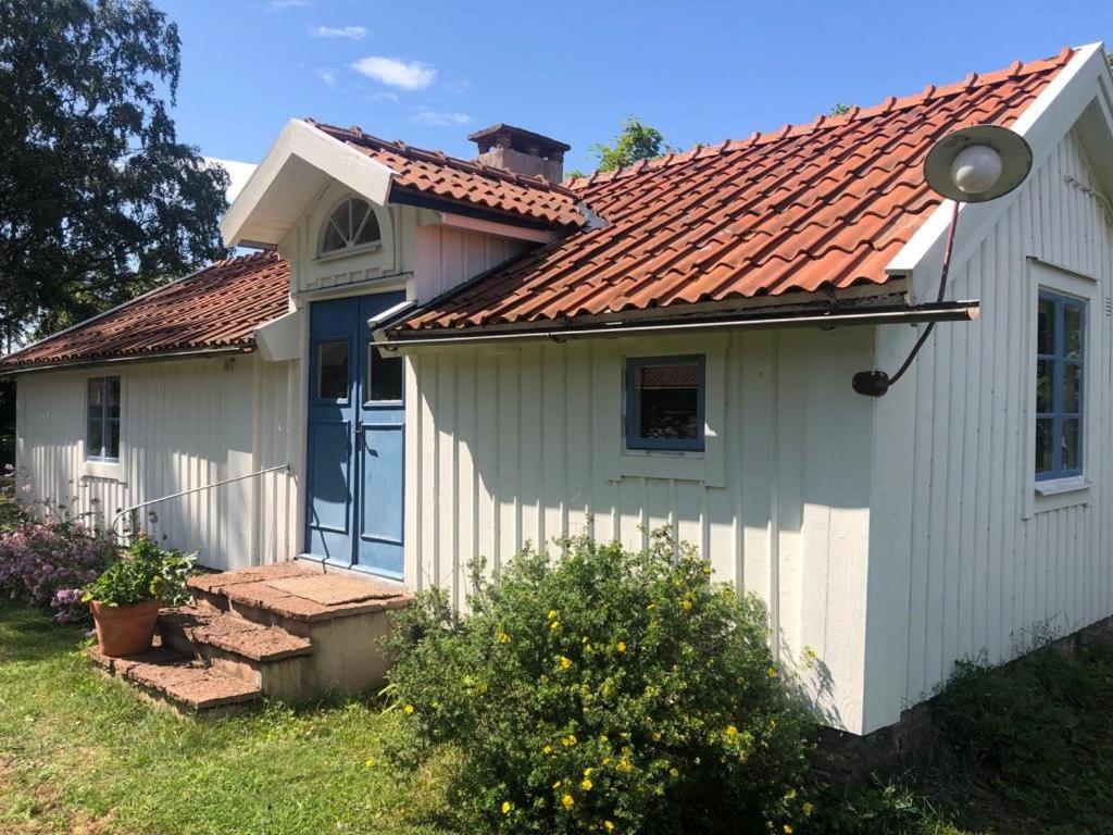 FröbygårdaSeaside Cottage Haga Park的一间白色的小房子,有红色的屋顶