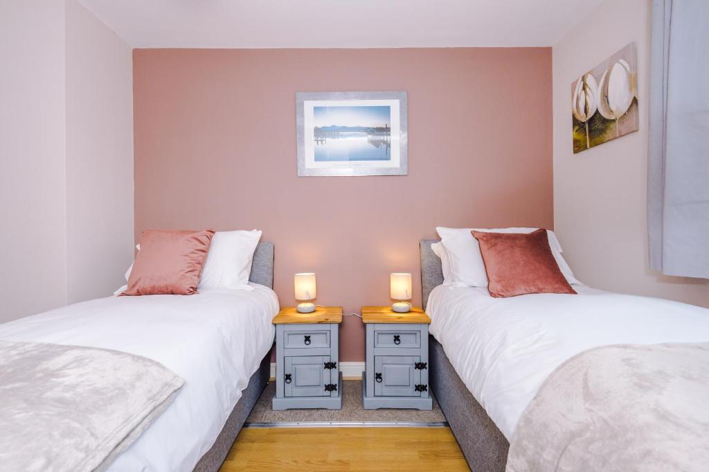 BroughtonRelaxing 3 Bedroom Chester Home with garden的配有两张单人床的房间,桌子上放着两把蜡烛