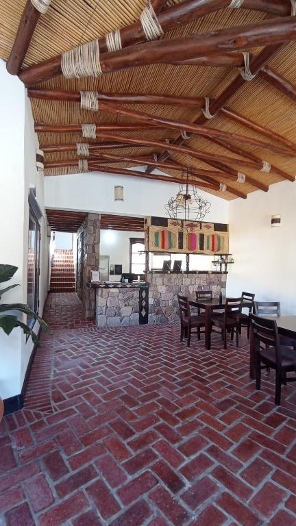普尔马马尔卡Hostería Aguas Coloradas的配有桌椅和石墙的房间