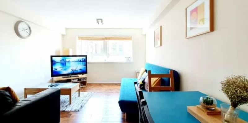 格拉斯哥2 Bedroom Apt in the Heart of the City Centre, perfect Location的客厅配有蓝色的沙发和电视