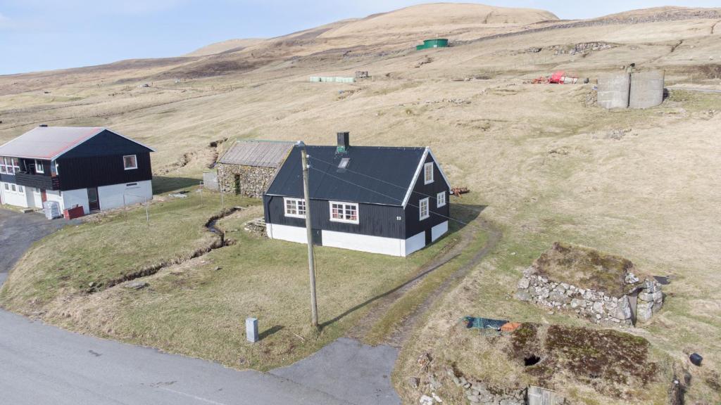 SkálavíkThe Real Faroese Experience的山丘上房屋的空中景致