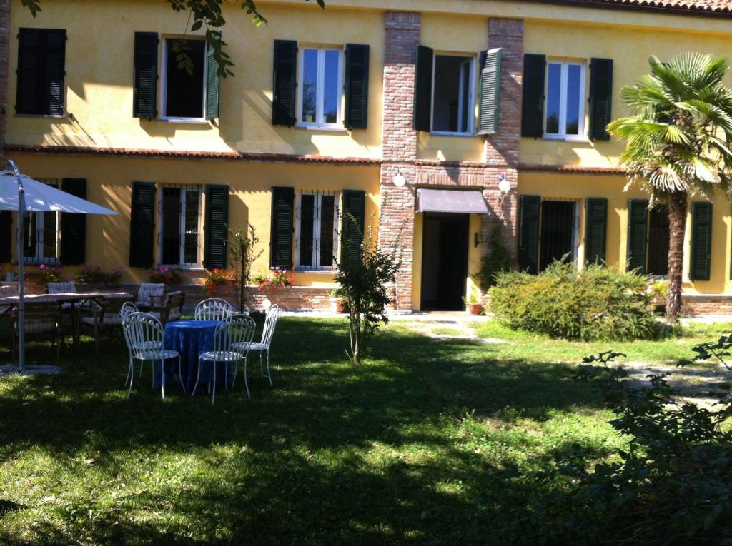 Rocca D'ArazzoCasale di Charme Bellaria的院子里带桌椅的房子