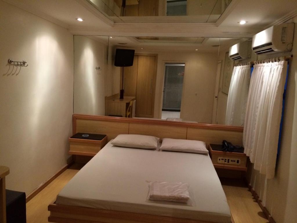 里约热内卢恩康特洛斯情趣酒店（仅限成人）的一间卧室配有一张床和一面大镜子