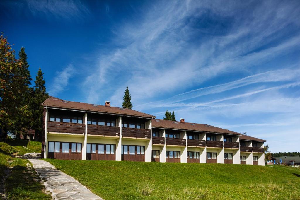 兹雷切Hotel Brinje的蓝天山上的建筑
