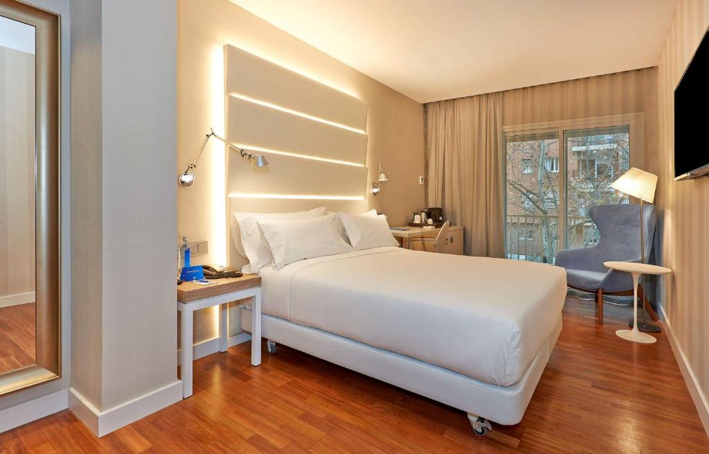 巴塞罗那巴塞罗那勒哥尔特NH酒店的卧室配有一张白色大床和一张书桌