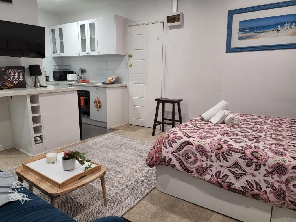 墨尔本St Kilda Lovely Studio Apartment的客厅配有床和桌子