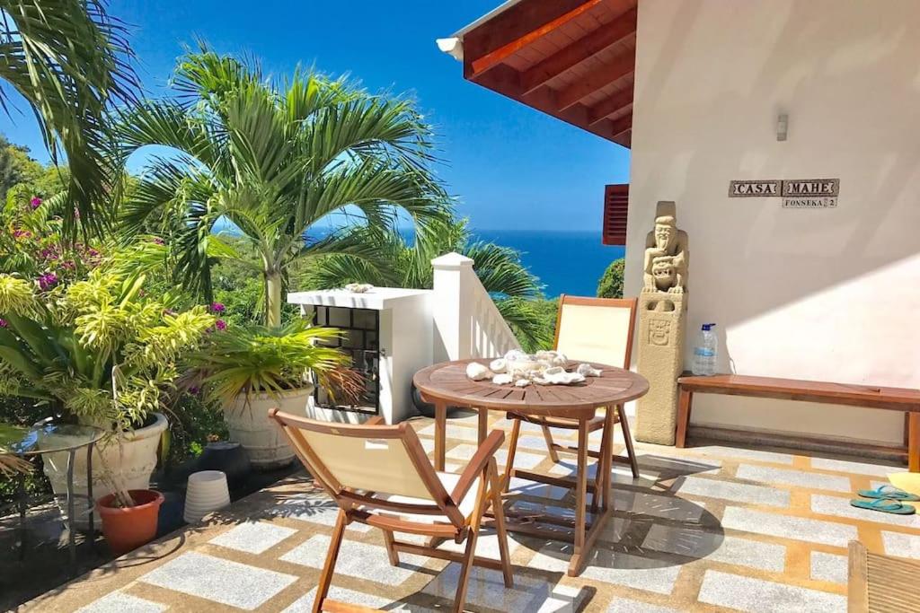 塔卡马卡Hilltop South - Villa Bougainville的一个带桌椅的庭院和大海