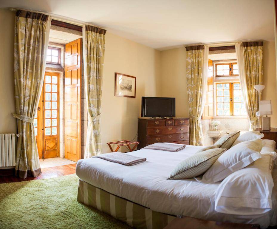 尼格兰帕佐图查酒店的一间卧室配有一张大床和电视