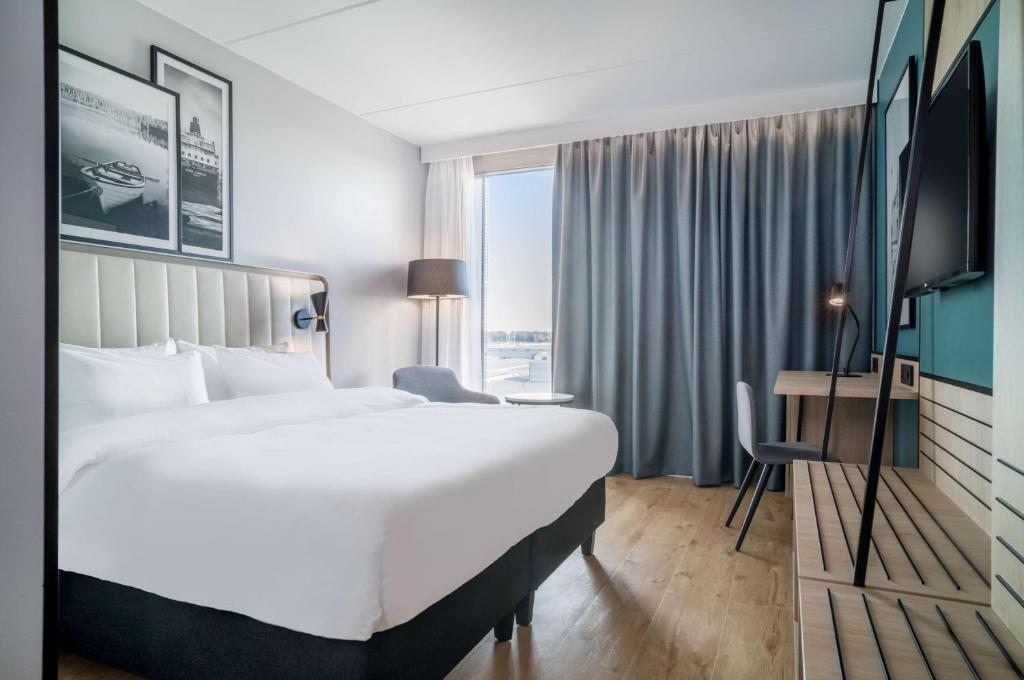 加勒穆恩Radisson Hotel & Conference Centre Oslo Airport的酒店客房设有一张大床和一台电视机。