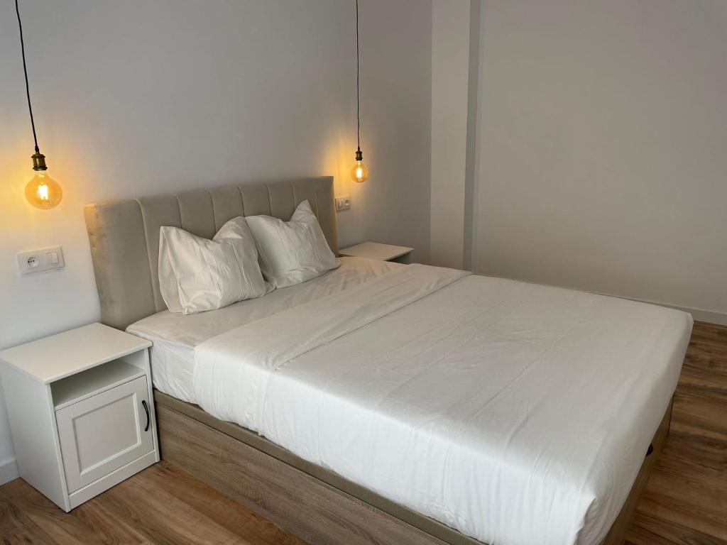圣卡洛斯拉腊皮塔Apartamento Dakota的卧室内的一张带白色床单和枕头的床