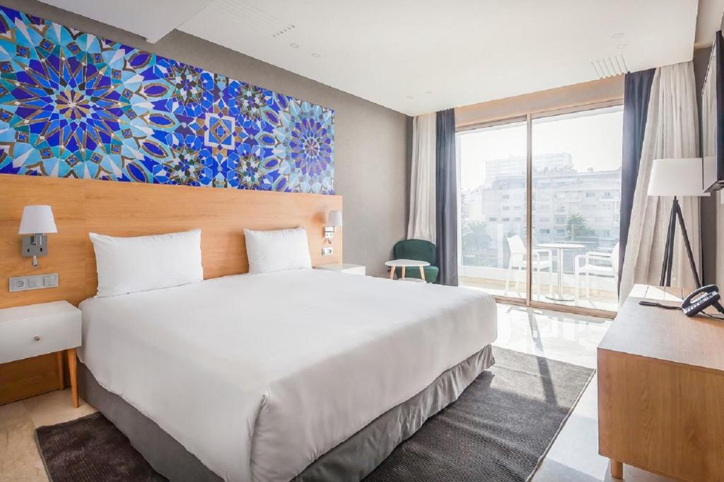 卡萨布兰卡Mid Town Hotel Casablanca的一间卧室设有一张大床和一个大窗户