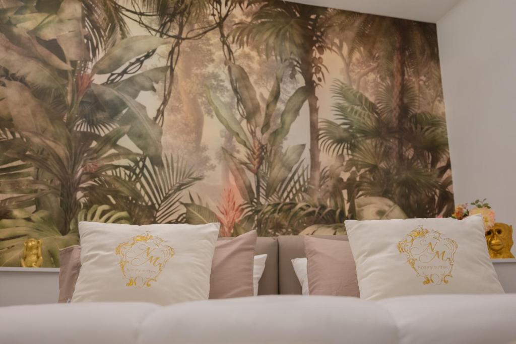 庞贝NM Luxury Suites的花卉墙前的一张带枕头的床
