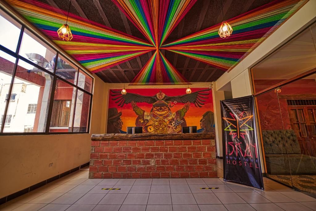 拉巴斯ISKAY BOUTIQUE HOSTEL的一间拥有色彩缤纷的天花板和壁画的房间