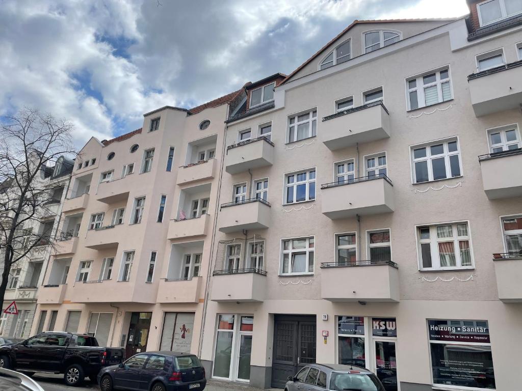 柏林Luxury 60m2 Appartement in Wilhelmstadt Berlin的一座大型建筑,前面有汽车停放