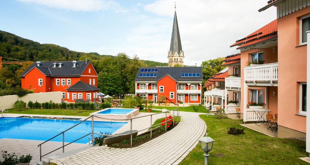 塔勒Hotelpark Bodetal mit Ferienwohnungen的一组建筑,有教堂背景