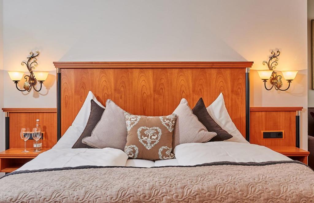 里登堡Landhotel Schneider的一张带木制床头板和枕头的大床