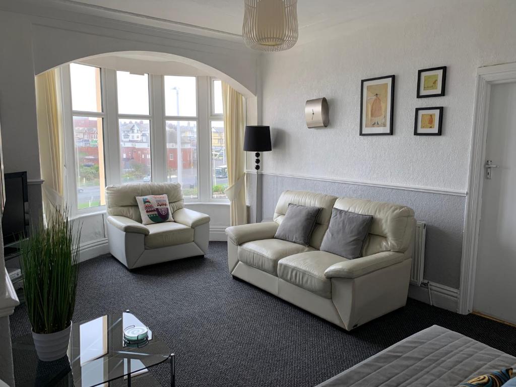 布莱克浦戴尔城堡假日公寓的客厅配有沙发和两把椅子
