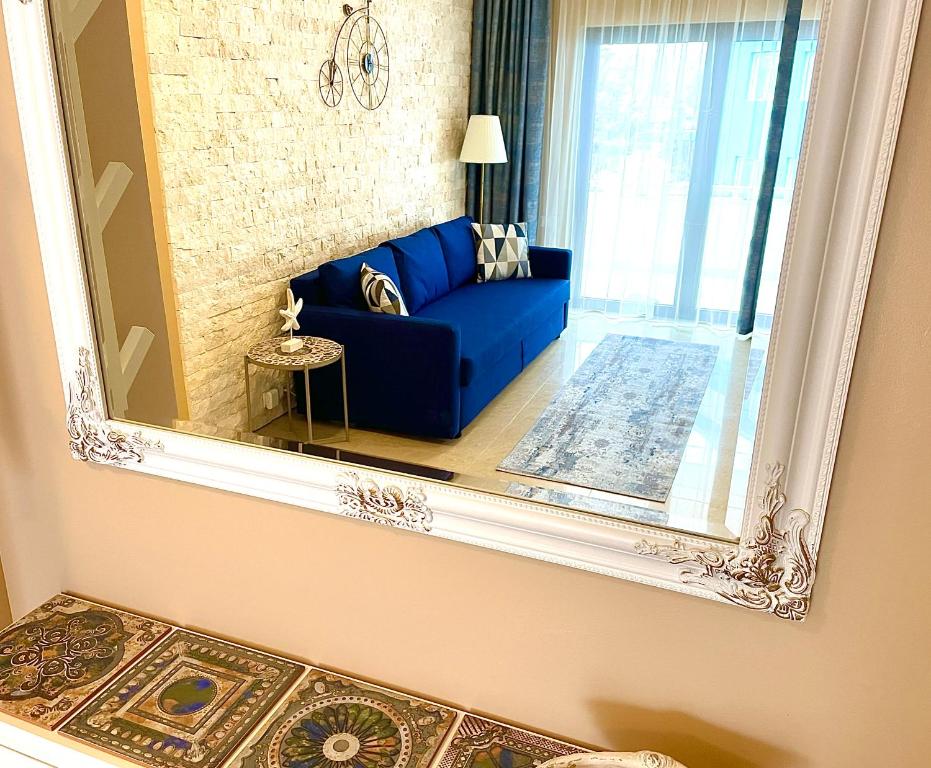 尼普顿Apartament Alexandru Neptun Private Suites的客厅配有蓝色沙发的镜子