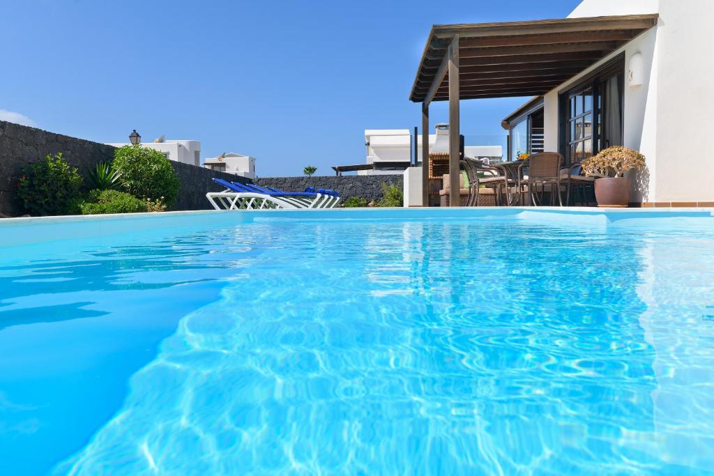 普拉亚布兰卡Hipoclub Villas, Aguamarina 27的一座房子前面的蓝色海水游泳池