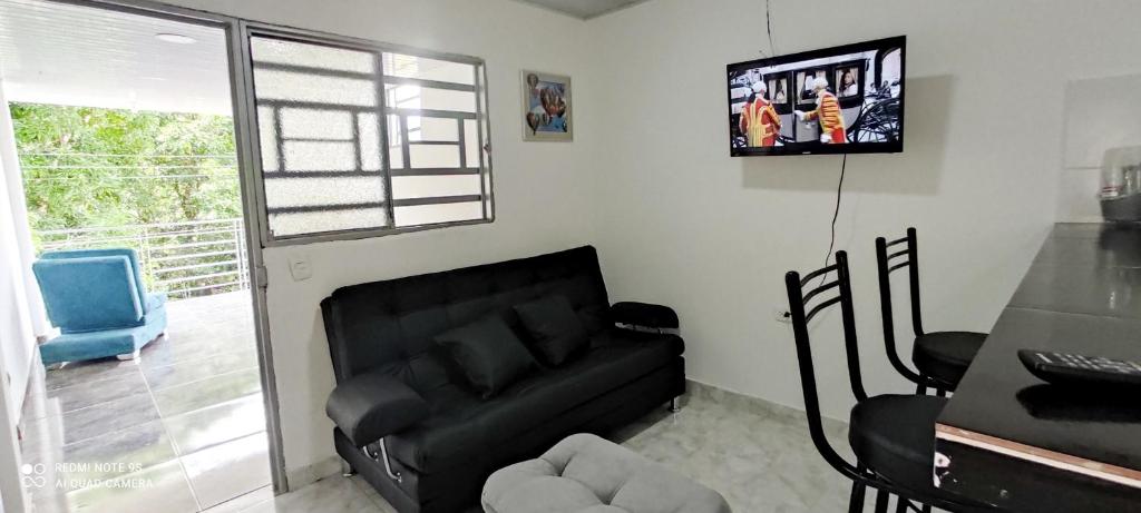 弗洛伦西亚Hermoso apartamento的客厅配有黑色沙发和电视