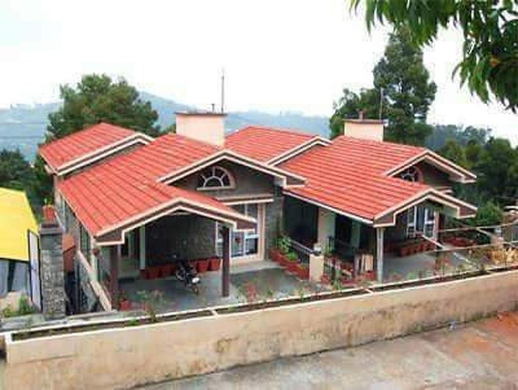 科代卡纳尔Kumaragiri Cottages Kodaikanal的街道上一座红屋顶的房子
