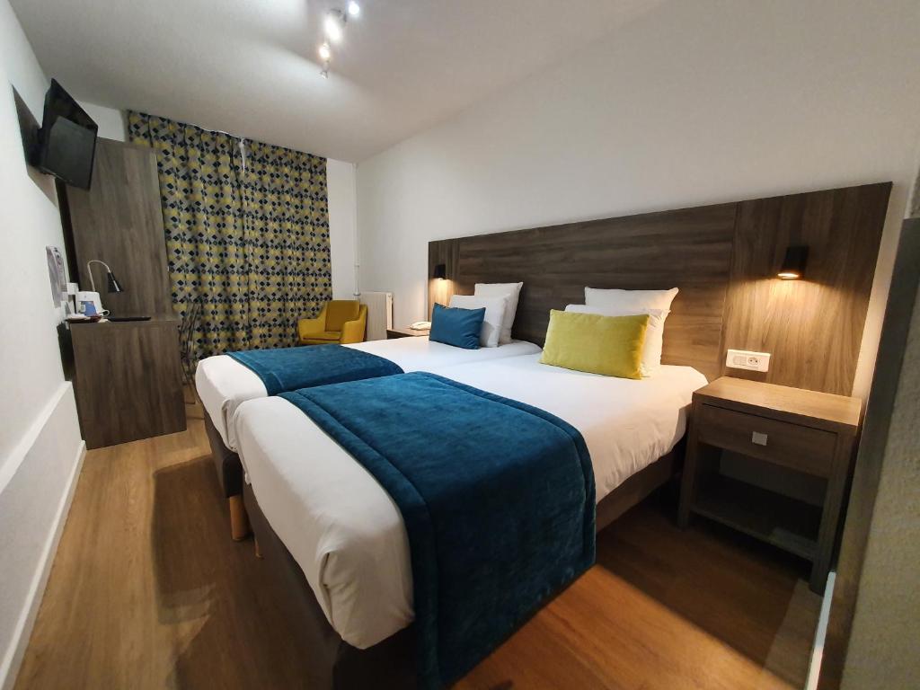 索恩河畔沙隆基里亚德夏龙苏尔萨纳中央酒店的一间卧室配有一张带蓝色毯子的大床