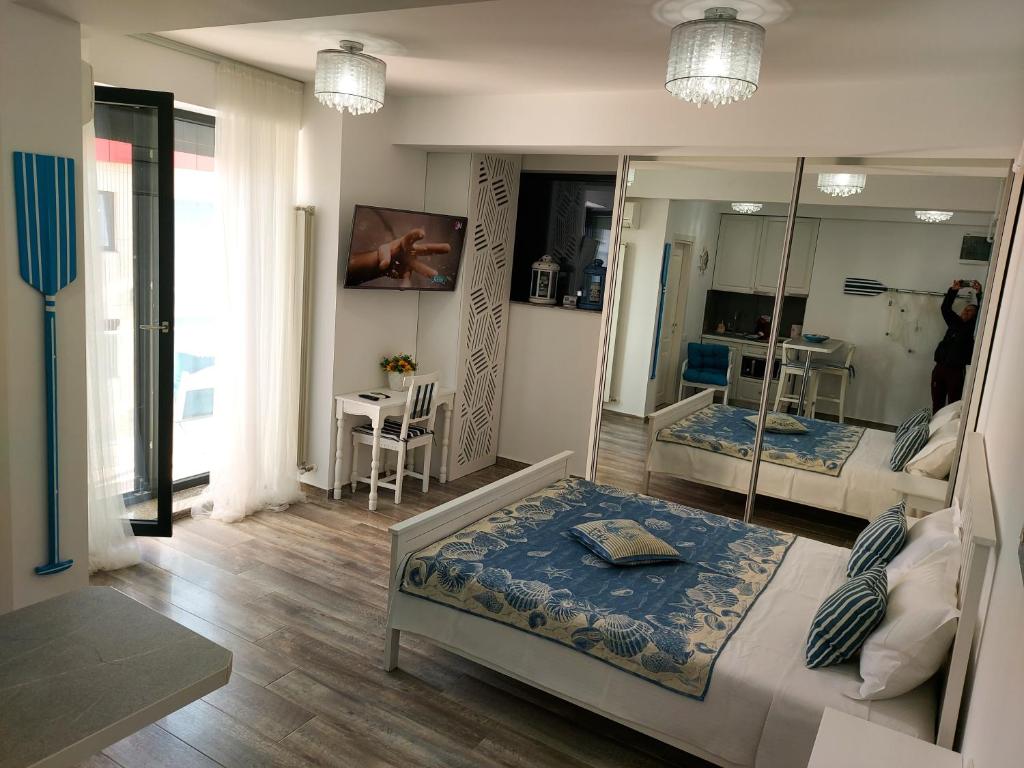 马马亚Bluemarina Apartamente的带两张床和镜子的客房