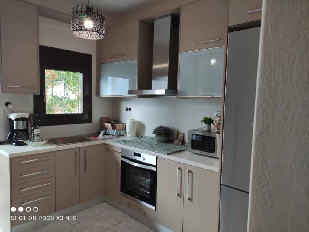 尼亚普拉加CHALKIDIKI NEA PLAGIA的厨房配有白色橱柜和炉灶烤箱。