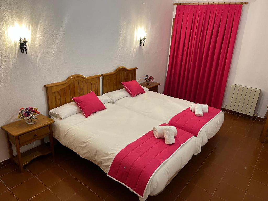 昆卡Hostal Ciudad Encantada的一间卧室配有两张红色窗帘