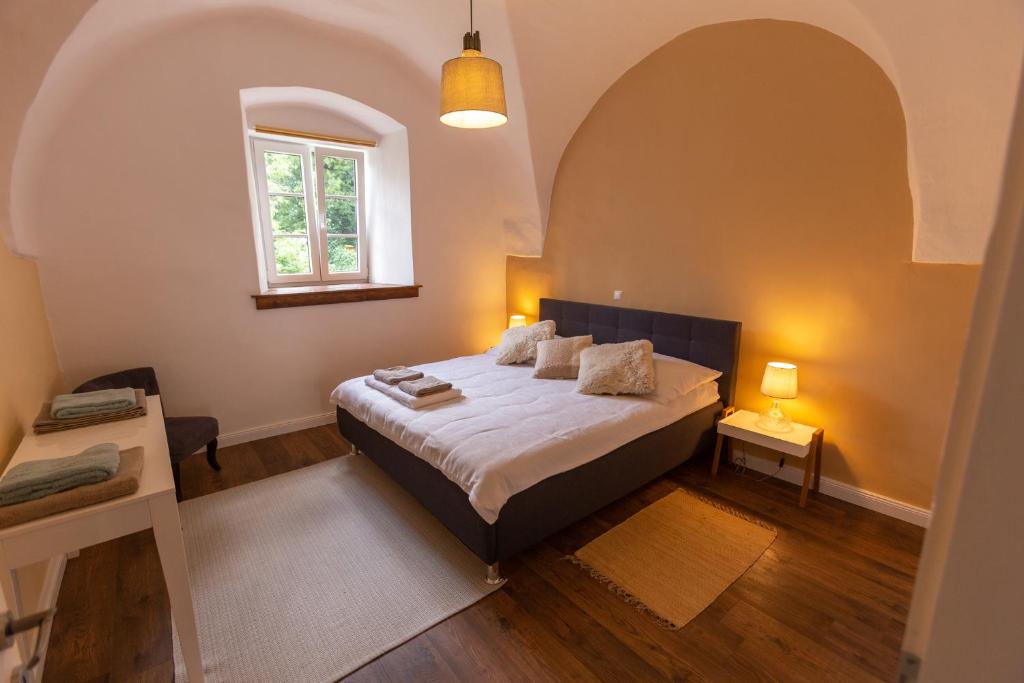 GörtschachPferdegut Schloss Treffen Apartments的一间带一张特大号床的卧室,位于带窗户的房间内
