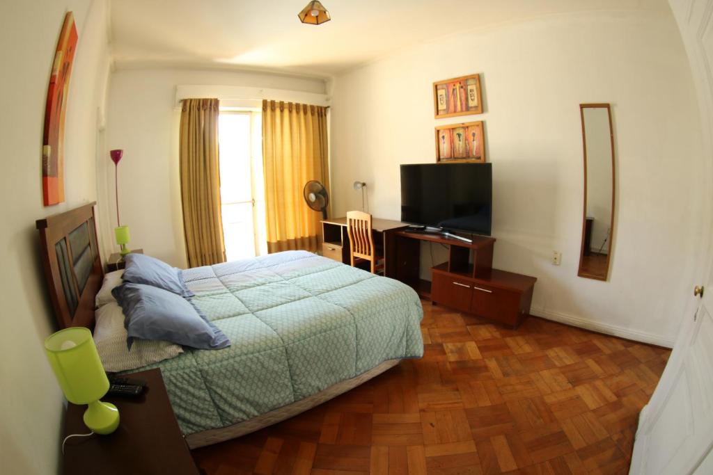 圣地亚哥德尔塞罗旅馆的一间卧室配有一张床、一张书桌和一台电视