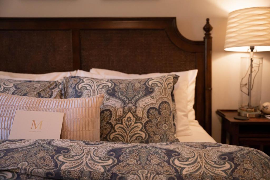 邓斯缪尔Mossbrae Hotel的酒店客房,配有一张带标志的床
