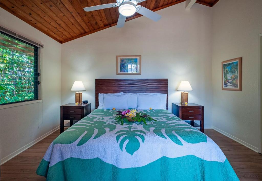 科洛阿Poipu Plantation Vacation Rentals的一间卧室,配有一张插花的床