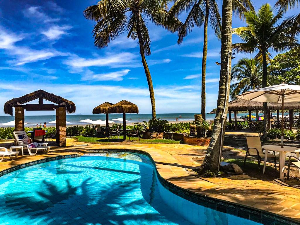 巴雷克萨巴芭乐格萨巴海滩酒店的一座棕榈树和海洋游泳池