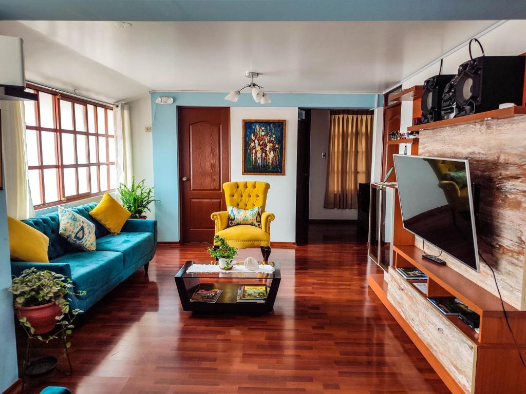 库斯科Casa de Laura的客厅配有蓝色的沙发和电视