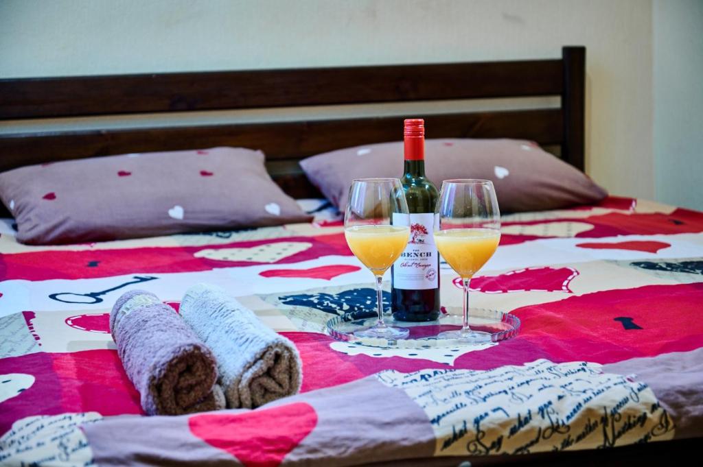 苏梅Троицкая люккс апартамены посуточно почасово的床上有一瓶葡萄酒和两杯酒