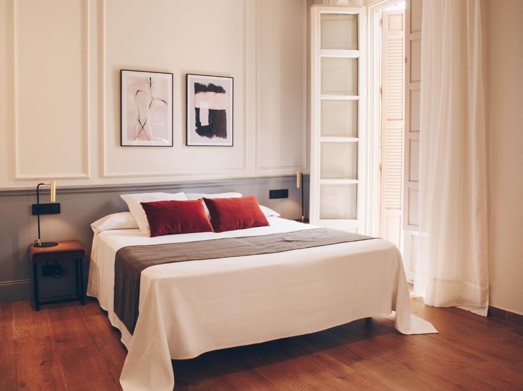 马拉加Alcazaba Premium Hotel的卧室配有带红色枕头的大型白色床