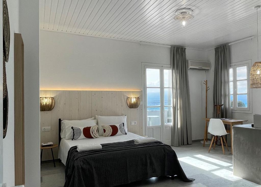 纳克索斯岛卡斯特拉基Thalassa Naxos的酒店客房设有一张床、一张书桌和窗户。
