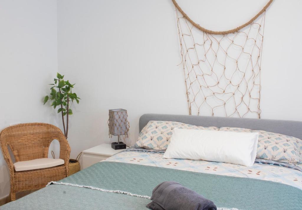 安波拉Netania的一间卧室配有一张带枕头和椅子的床